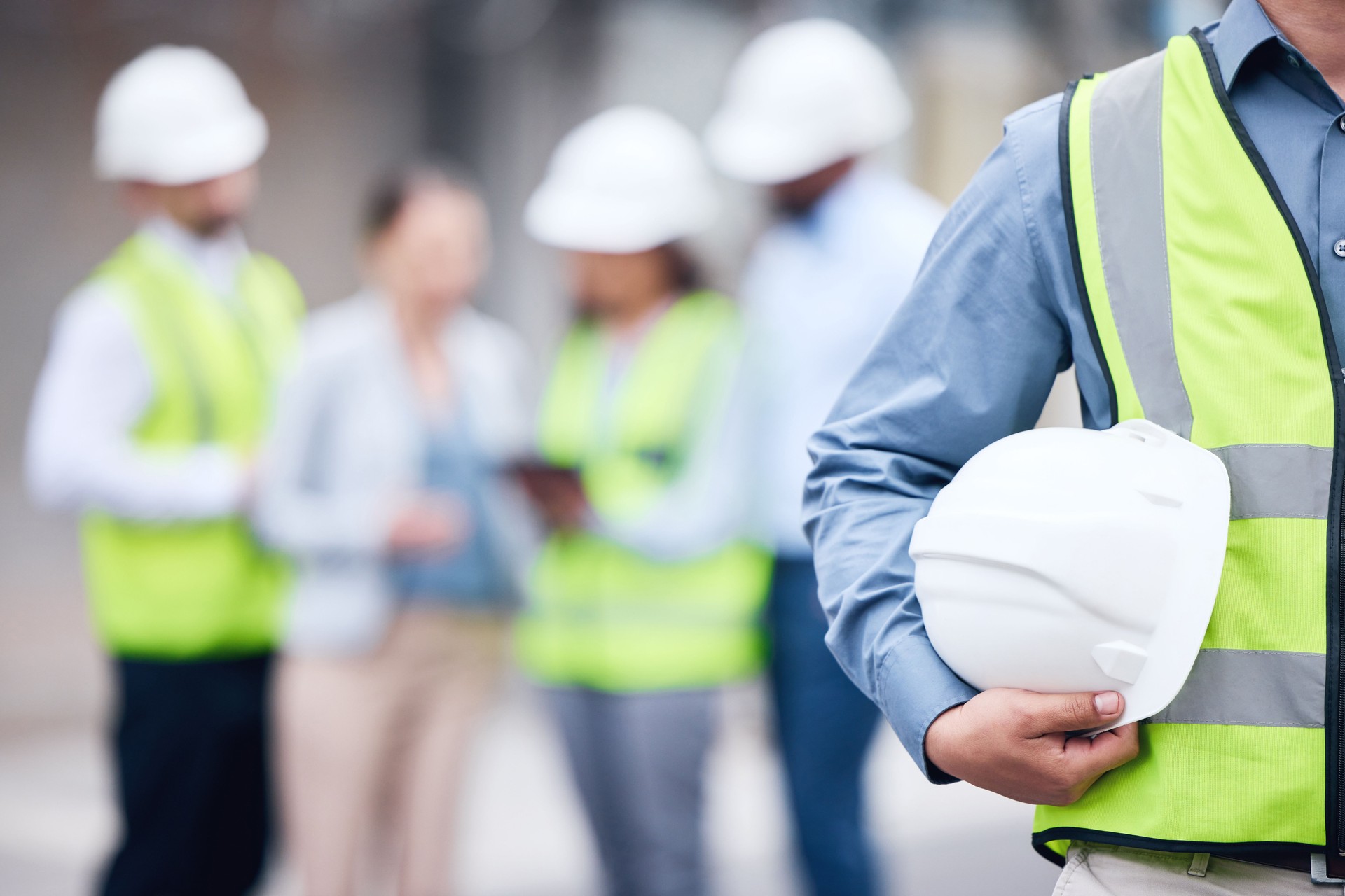 Shot of an unrecognizable architect holding a helmet at a building site